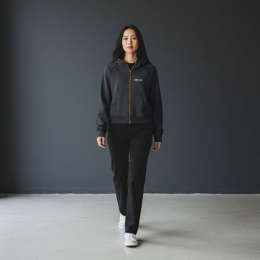 Omina Essentials women's cropped zip-through hoodie in dark grey, made from soft premium fabric with adjustable hood and ribbed cuffs.