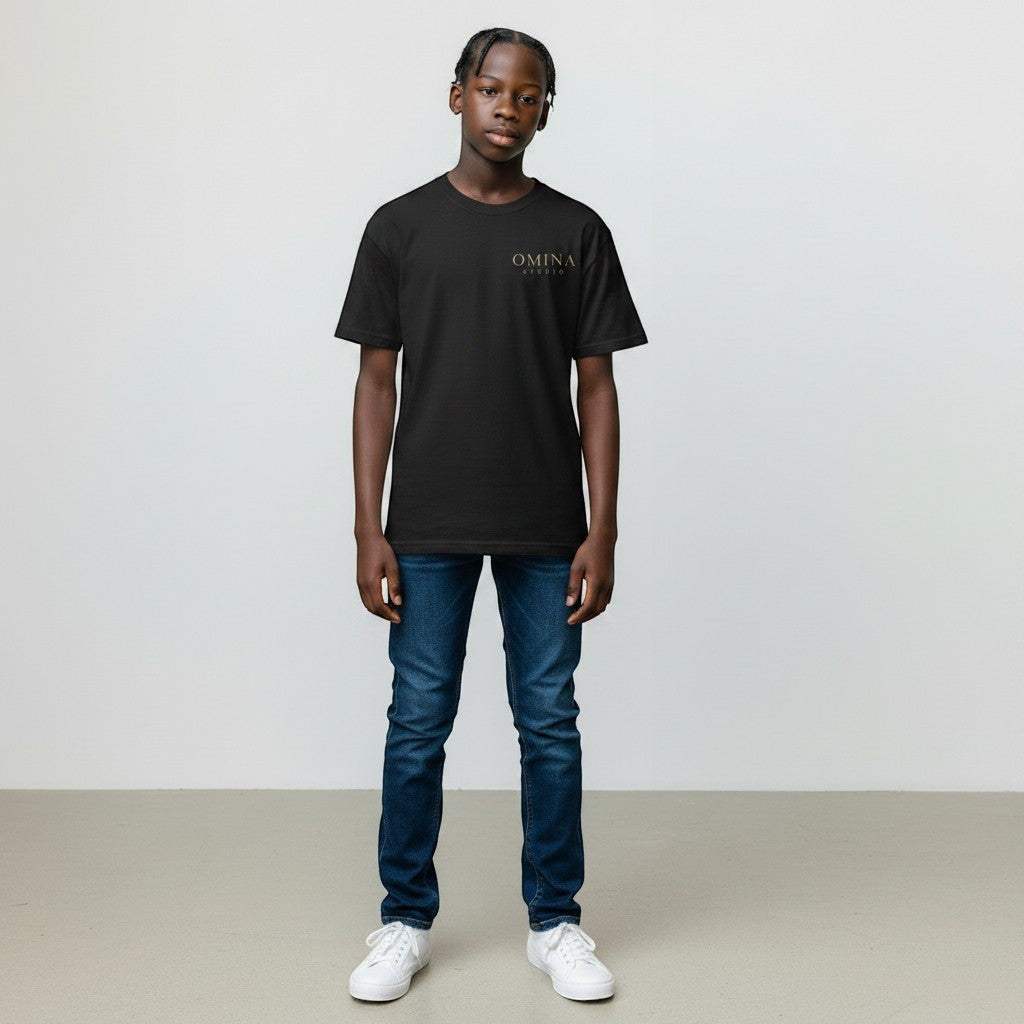 Omina Studio black premium cotton t-shirt with minimalist gold logo on the chest, worn by a young person.