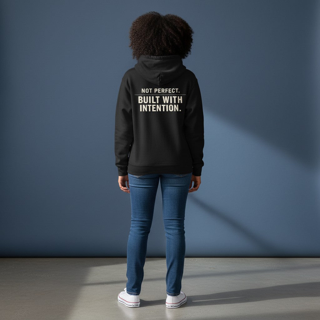 Omina black fleeced boxy hoodie with "NOT PERFECT. BUILT WITH INTENTION." graphic on back.