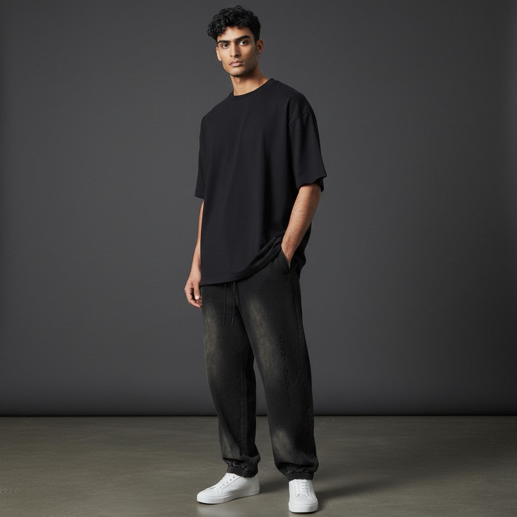 Omina Studio black washed cotton blend sweatpants with vertical FORM / IDENTITY logo detail and drawstring waist.