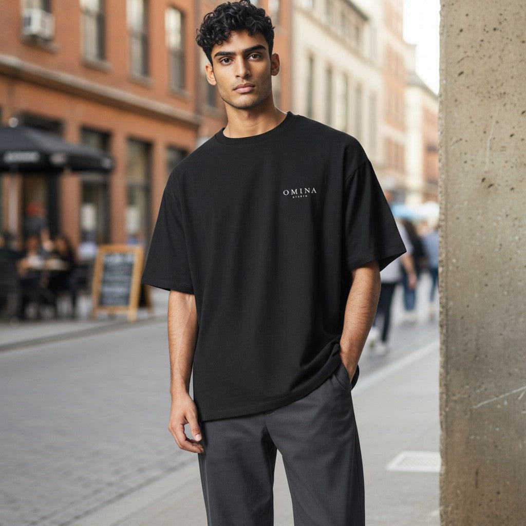OMINA Studio black heavyweight cotton t-shirt with subtle logo print on chest. Crew neck, short sleeves, durable construction.
