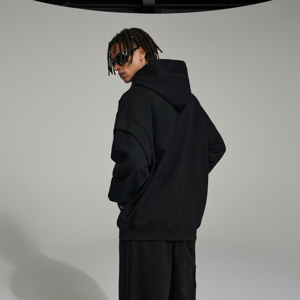 Omina black cotton-blend zip hoodie with raw edge detailing and contrast tape accents. Oversized fit.
