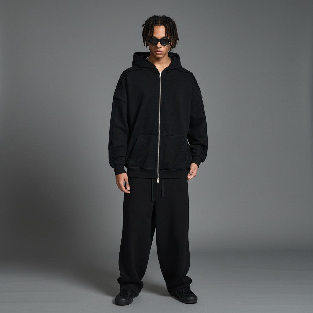 Omina black cotton-blend zip-up hoodie with raw edge detailing and contrast tape accents. Oversized fit.