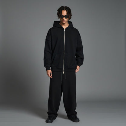 Omina black cotton-blend zip-up hoodie with raw edge detailing and contrast tape accents. Oversized fit.