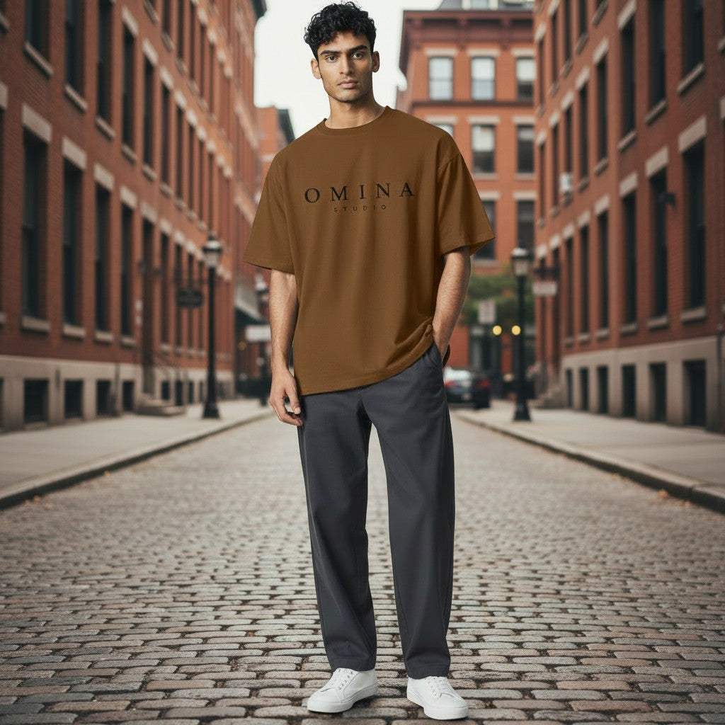 Omina Studio brown heavyweight cotton t-shirt with relaxed fit and dropped shoulders, worn by a man outdoors.