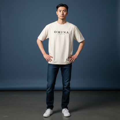 Omina Studio cream cotton t-shirt with minimalist black logo graphic on the chest. Short sleeves and crew neck.