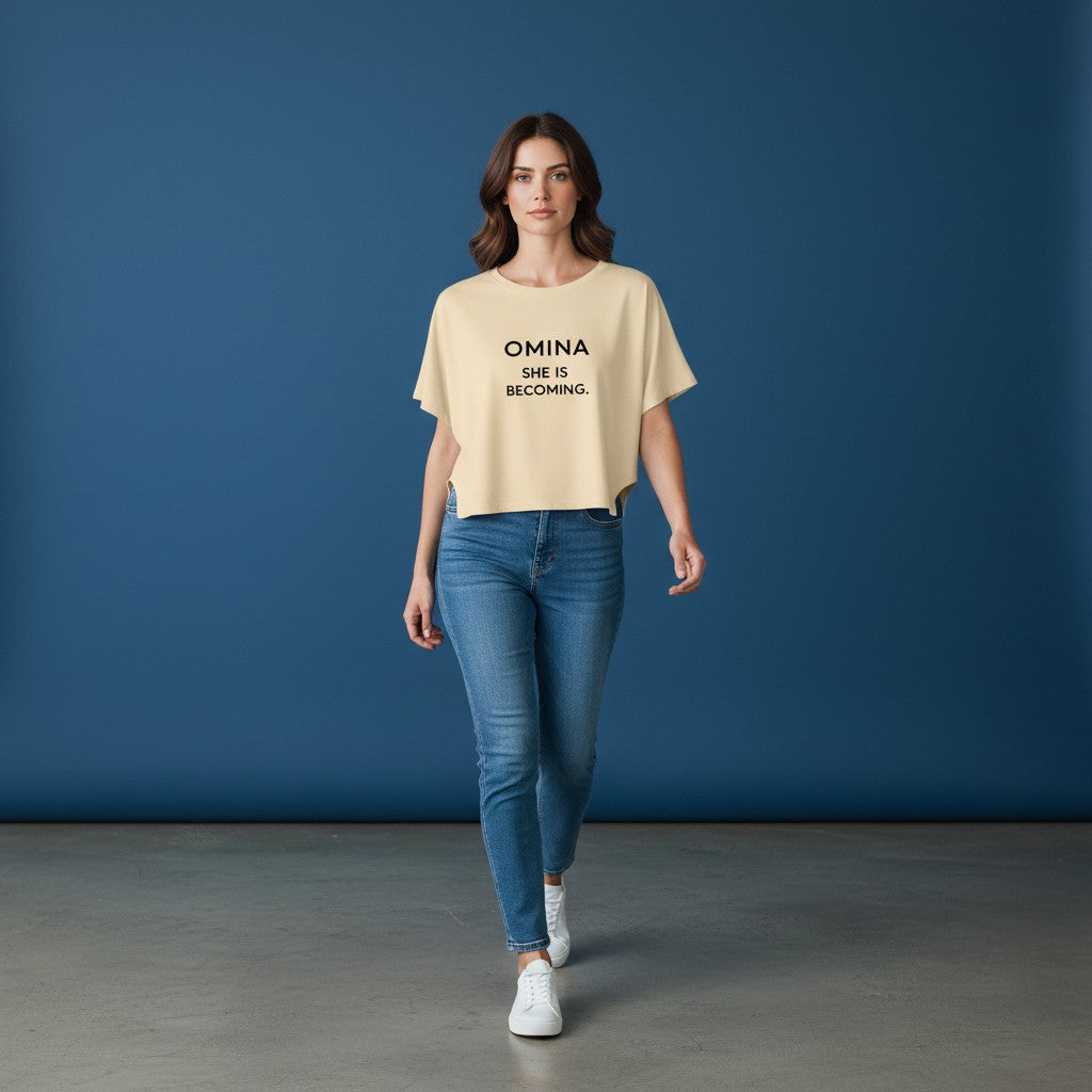 Omina women's cream cropped dolman t-shirt with black text "OMINA SHE IS BECOMING."
