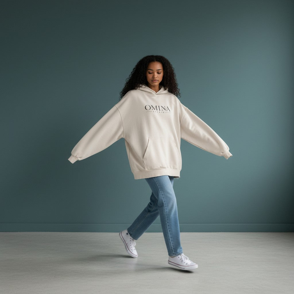 Omina oversized distressed cream cotton hoodie with frayed details and Omina Studio logo.