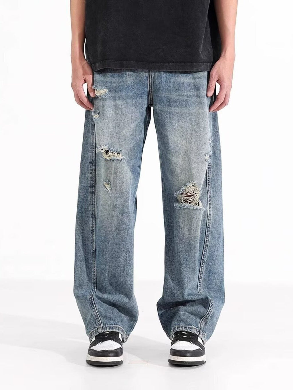 Omina blue wash distressed wide leg denim jeans on a male model.