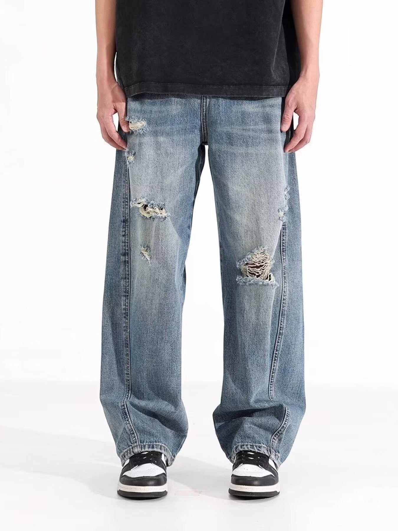Omina blue wash distressed wide leg denim jeans on a male model.