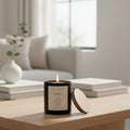 Omina Essence STILL black candle with wooden lid, burning with a soft flame. Ambre, sandalwood, jasmine scent.