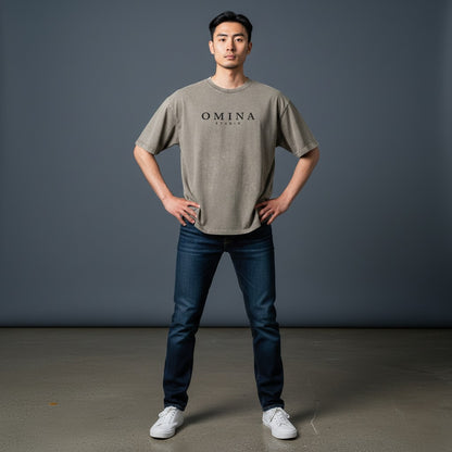 Omina Studio grey washed cotton t-shirt with black minimalist logo graphic on chest.