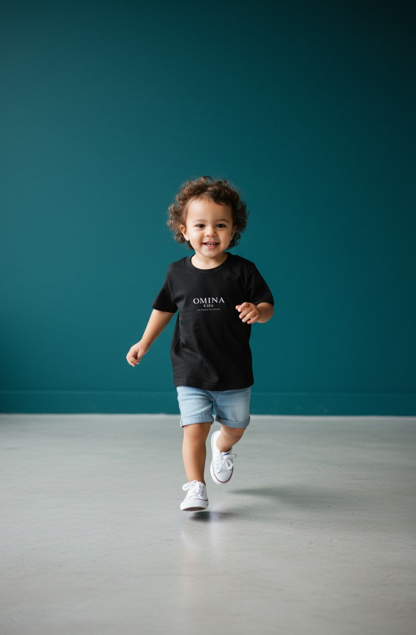 OMINA Kids black cotton t-shirt with minimalist logo print on chest. Comfortable, breathable, and durable for everyday play.