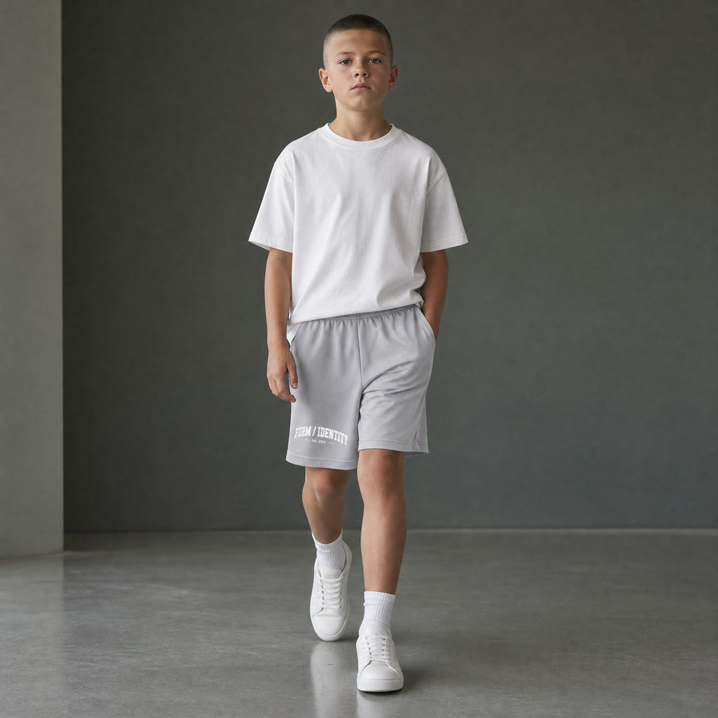 Omina Kids Youth Form / Identity shorts in light grey with elastic waistband and white graphic logo on left leg.