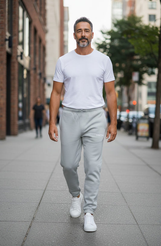 Omina Studio light grey relaxed fit track pants with drawstring waist and cuffed ankles.