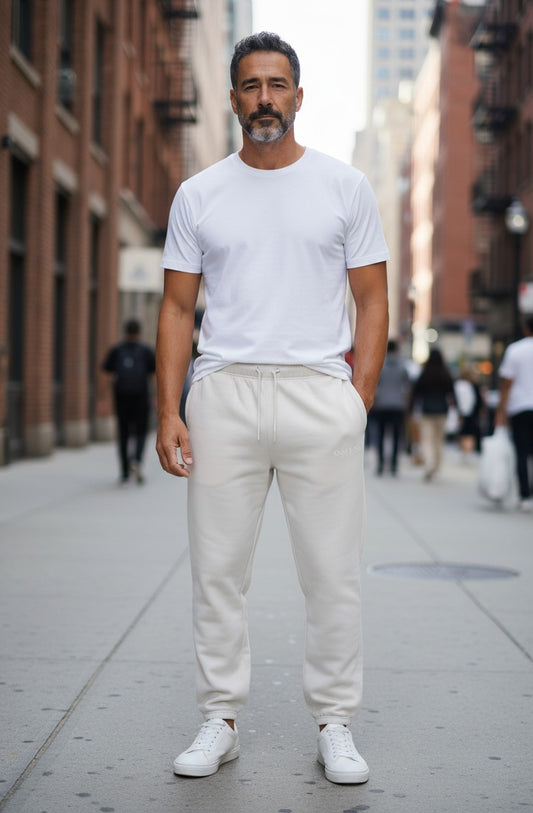 Omina Studio light grey relaxed fit track pants with drawstring waist and cuffed ankles. Soft cotton blend.