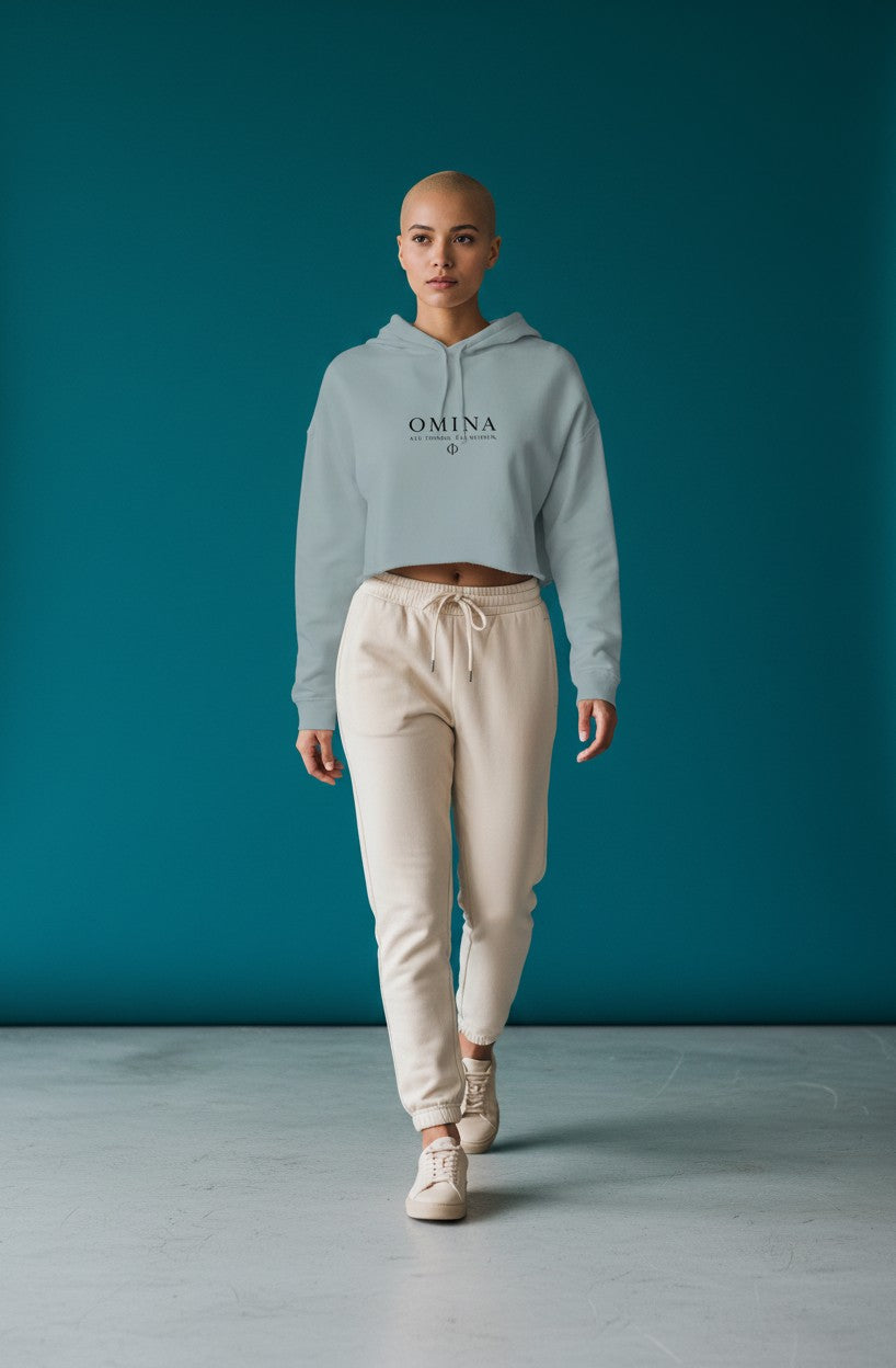 Omina Studio light blue lightweight cropped hoodie with adjustable drawstring hood and raw hem. Features Omina logo.