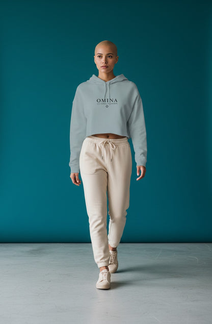 Omina Studio light blue lightweight cropped hoodie with adjustable drawstring hood and raw hem. Features Omina logo.