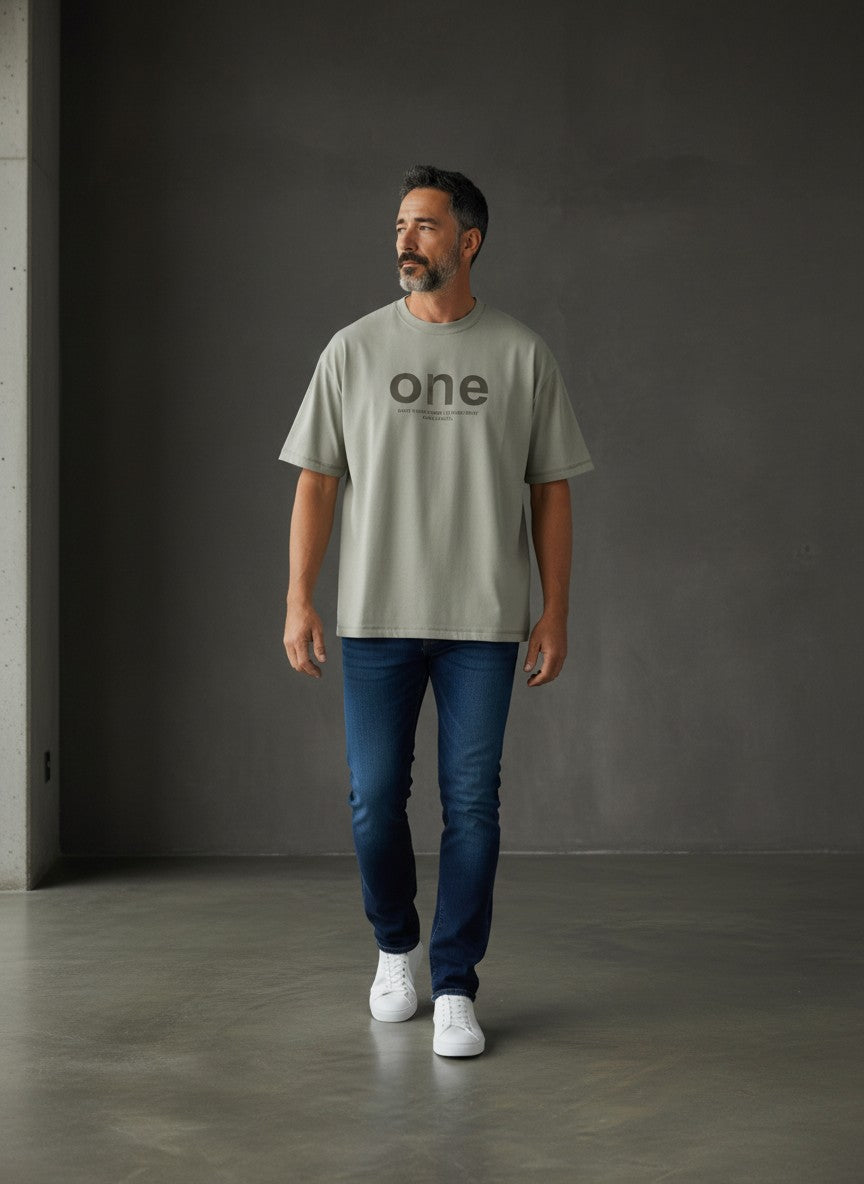Omina men's oversized light grey short sleeve t-shirt with 'one' graphic and text detail. Made of 95% cotton, 5% spandex.
