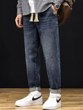 Omina relaxed fit blue denim trousers with drawstring waist and utility pockets, cuffed hem.