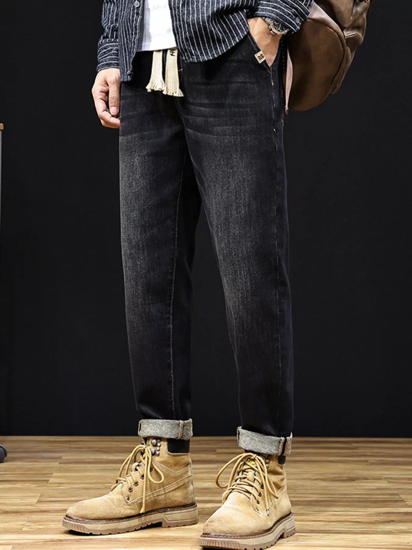 Omina relaxed fit dark wash denim trousers with drawstring waist and utility pockets, cuffed hem.