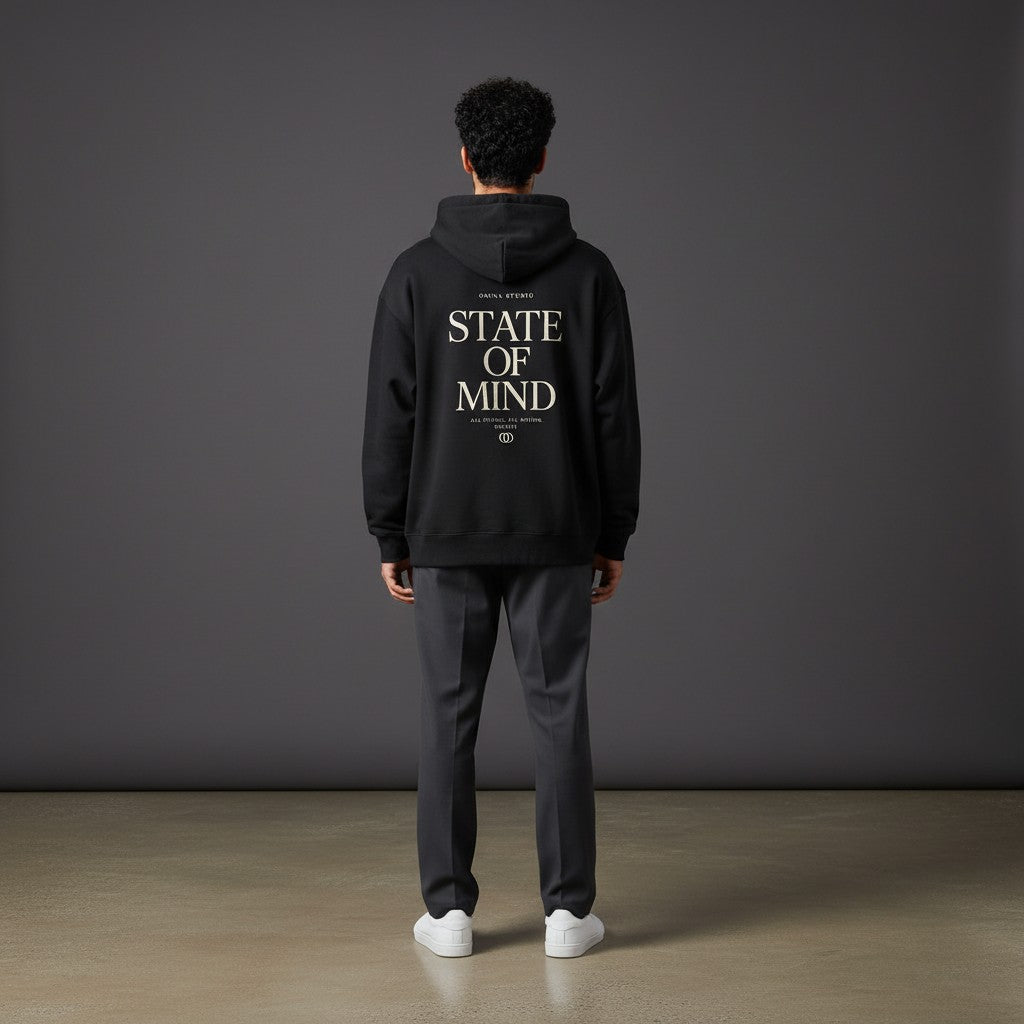Omina Studio black heavyweight hoodie with "State of Mind" graphic print on back, relaxed fit, and raw edge details.