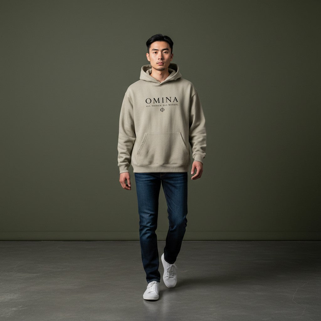 Omina Studio beige heavyweight fleece drop-shoulder hoodie with black text logo and pocket.
