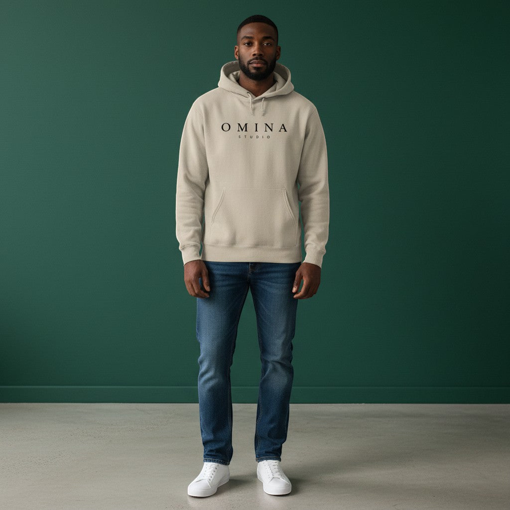 Omina Studio beige pigment-dyed cotton blend hoodie with front wordmark and relaxed fit.