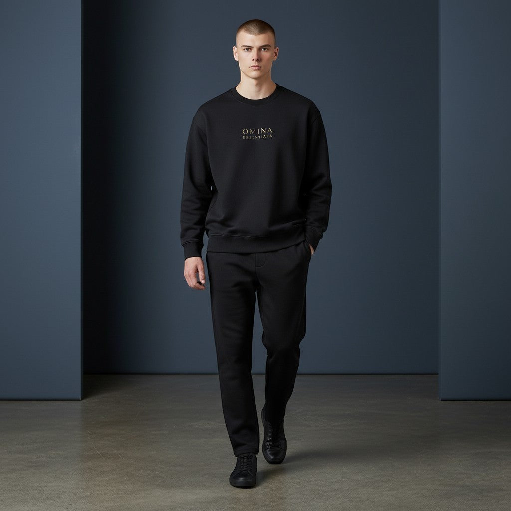 OMINA Studio black heavyweight cotton sweatshirt with crew neck and subtle gold logo detail. Oversized fit.