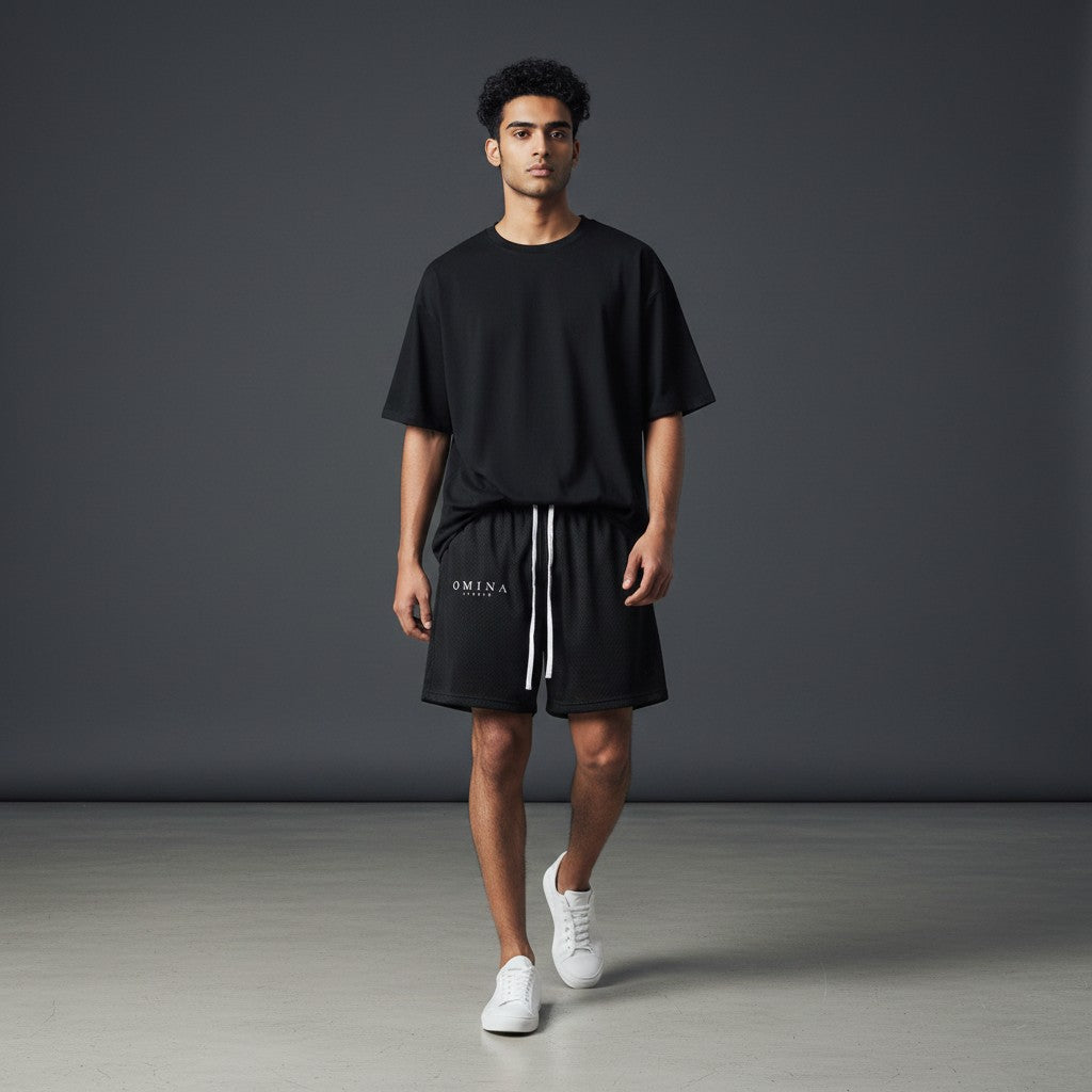 Omina Studio black mesh drawstring shorts with white logo and drawstrings, relaxed fit, breathable fabric.