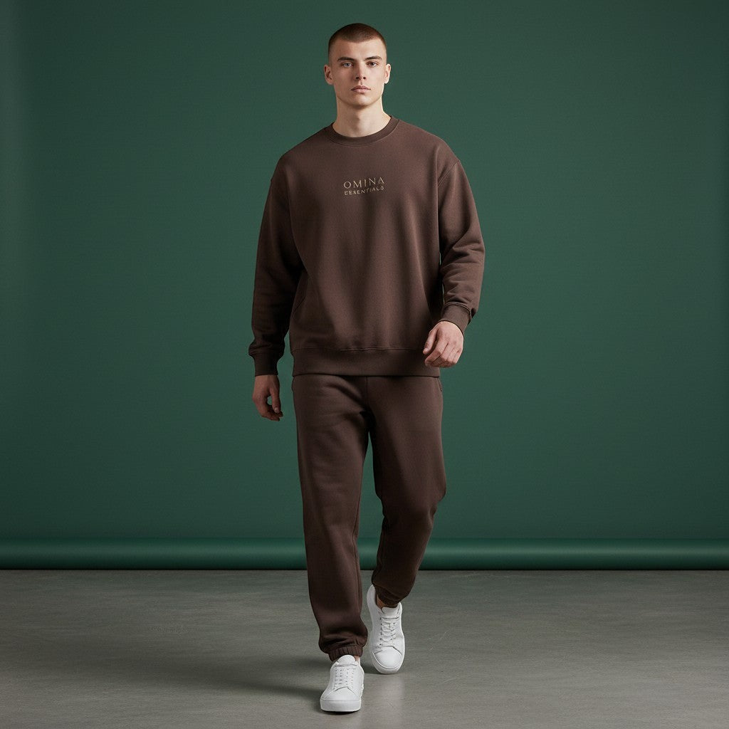OMINA Studio brown heavyweight cotton sweatshirt with oversized fit and subtle logo detail. Model wears matching sweatpants.