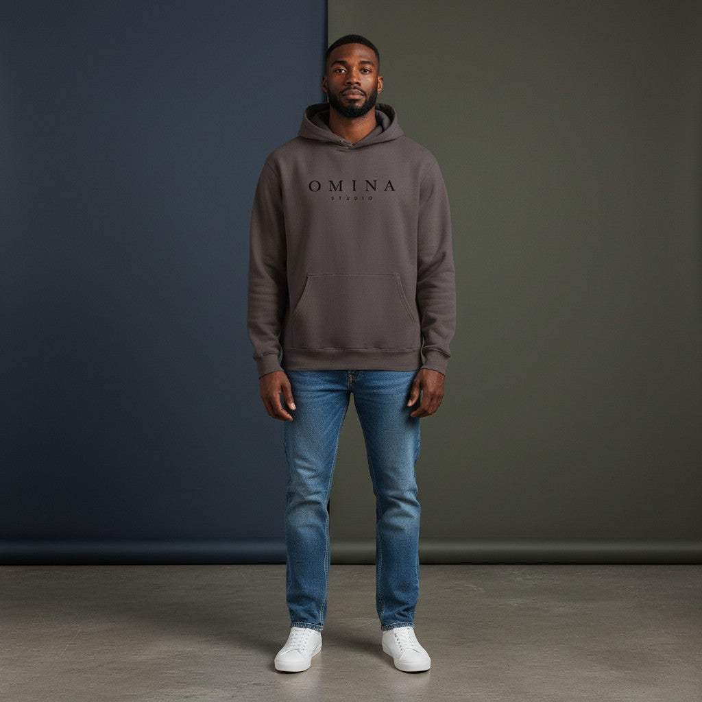 Omina Studio pigment-dyed brown cotton blend hoodie with front logo and pouch pocket.