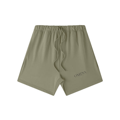 Omina Studio olive green heavyweight French terry shorts with drawstring and subtle logo detail.