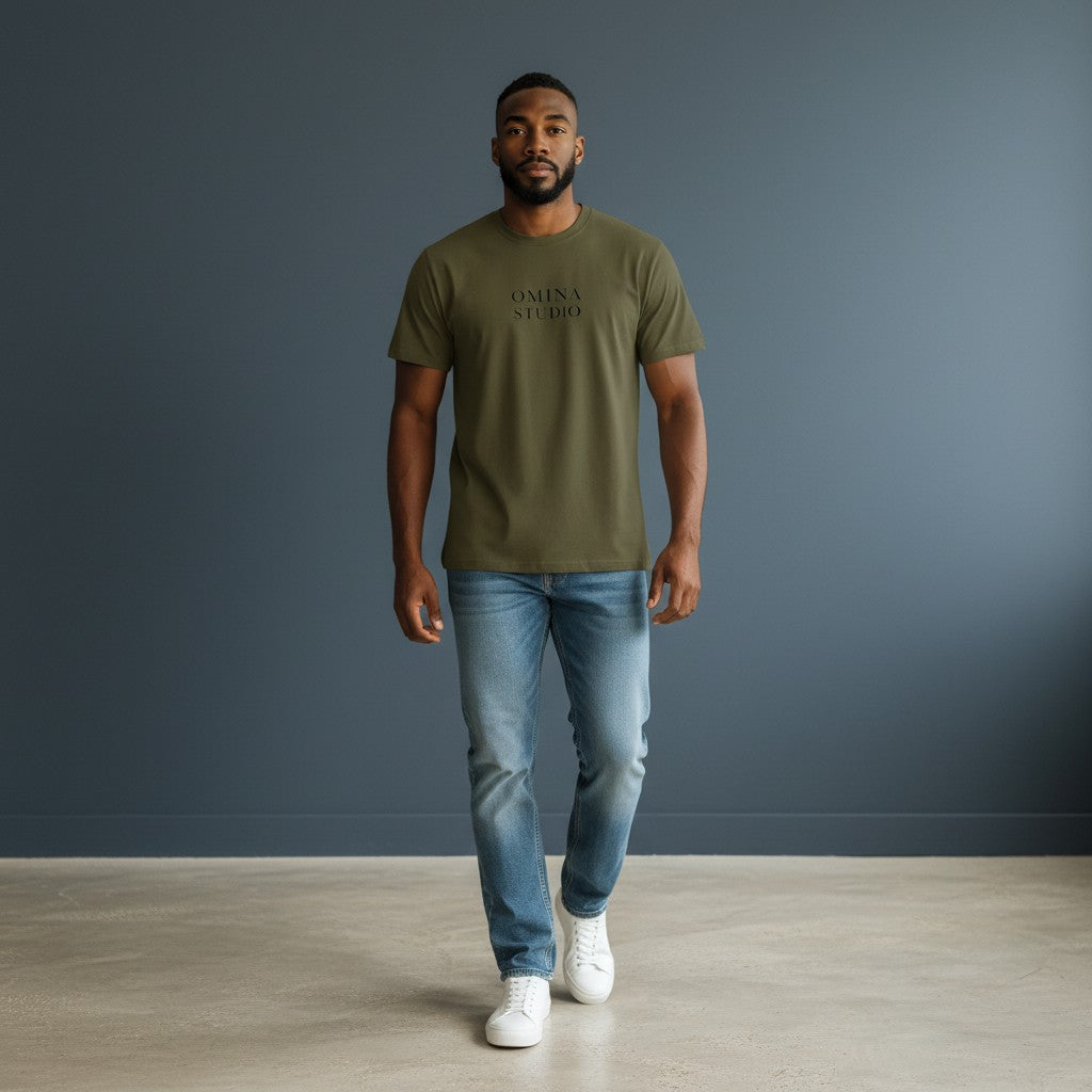 Omina Studio olive green heavyweight cotton t-shirt with drop shoulders and subtle logo on a man wearing jeans.