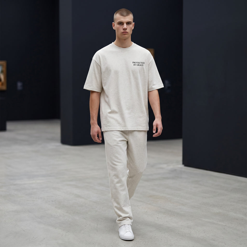 OMINA Studio light grey heathered cotton t-shirt with "PROTECTED BY GRACE" text on the left chest.