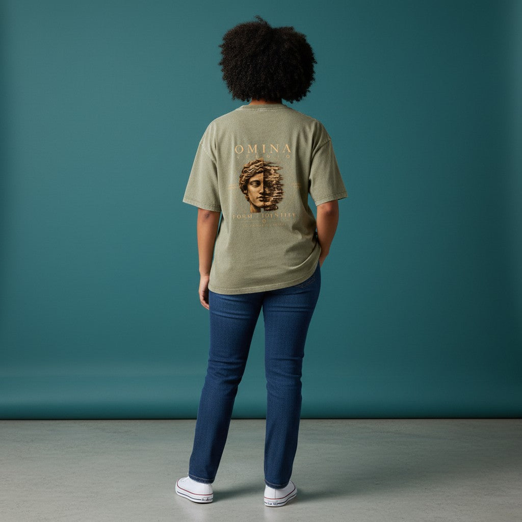 Omina Studio unisex vintage wash boxy t-shirt in olive green, featuring a distressed graphic of a classical bust split in half with text.
