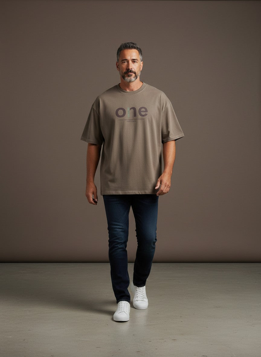 Omina men's oversized short sleeve t-shirt in taupe with a large 'one' graphic and text detail. Made of cotton and spandex.