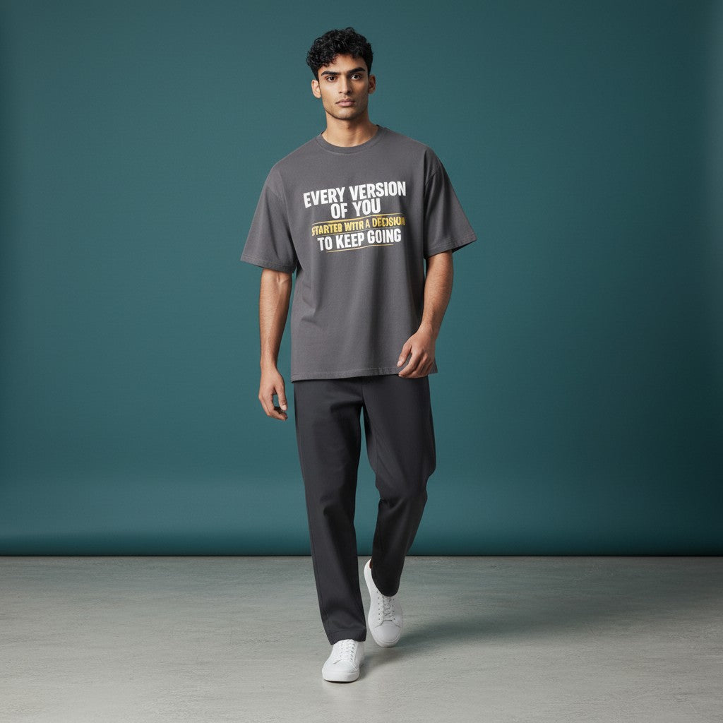 Omina dark grey 100% cotton unisex vintage wash boxy t-shirt with a round neck and drop shoulders, featuring a white and yellow text graphic.
