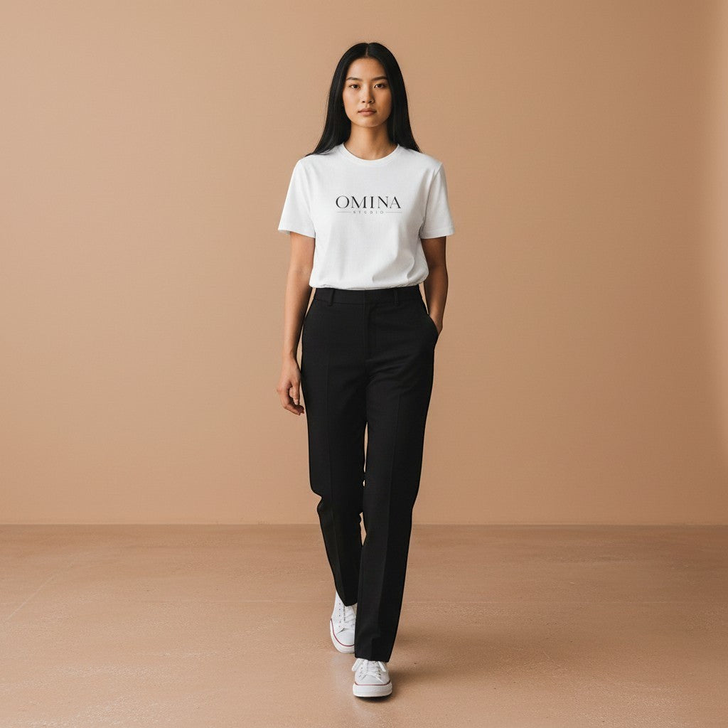 Omina Studio white cotton t-shirt with minimalist front logo and bold graphic back print. Model wears relaxed fit tee with black trousers.