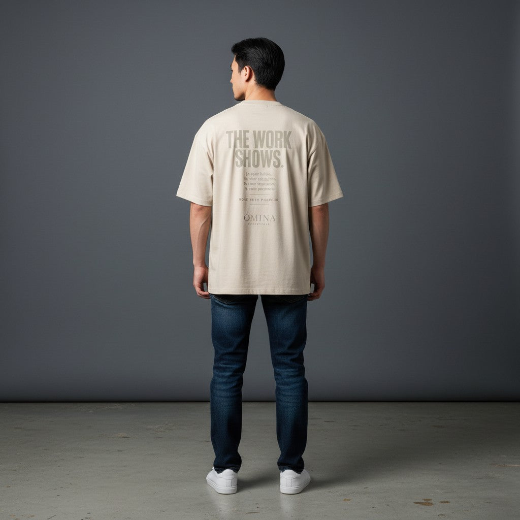 Omina beige cotton t-shirt with "The Work Shows" graphic print on back, relaxed fit, worn by a man.