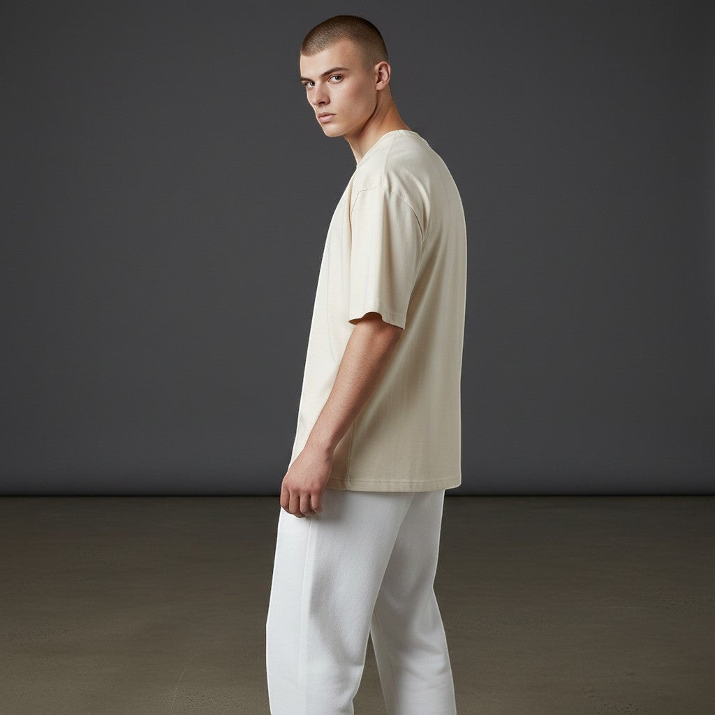 Omina Studio relaxed fit cream cotton t-shirt and white trousers set on a male model.