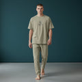 Omina Studio men's relaxed fit light olive cotton t-shirt and matching trousers set with subtle logo.